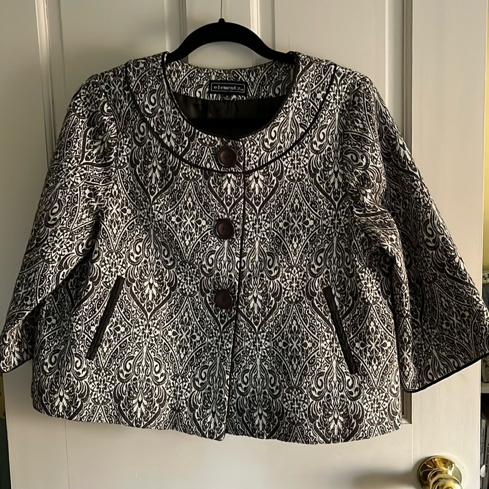 Jacket of brocade like fabric, lined.  Cropped, swing, back pleat style.